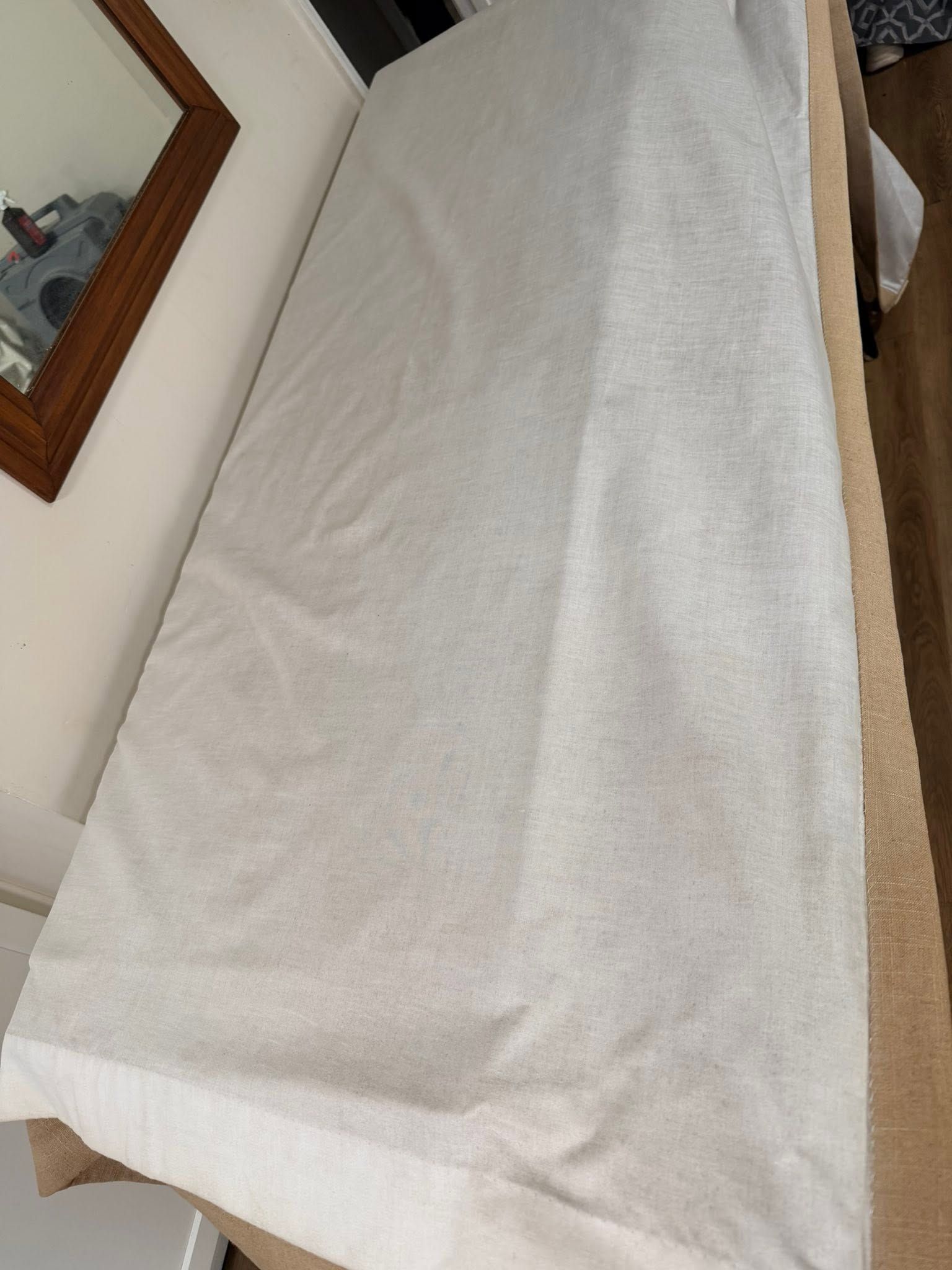 A clean white drape with a tan border, laid flat on a table