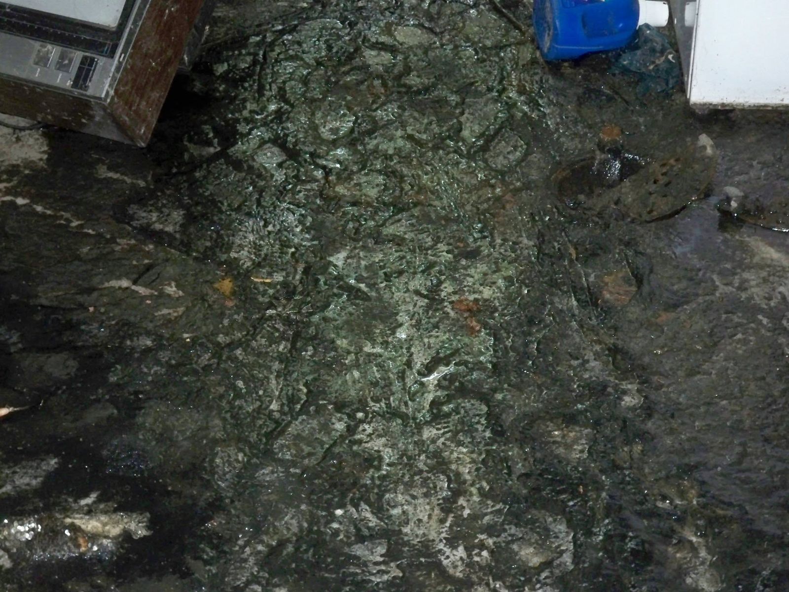 Dark water and debris covering a floor