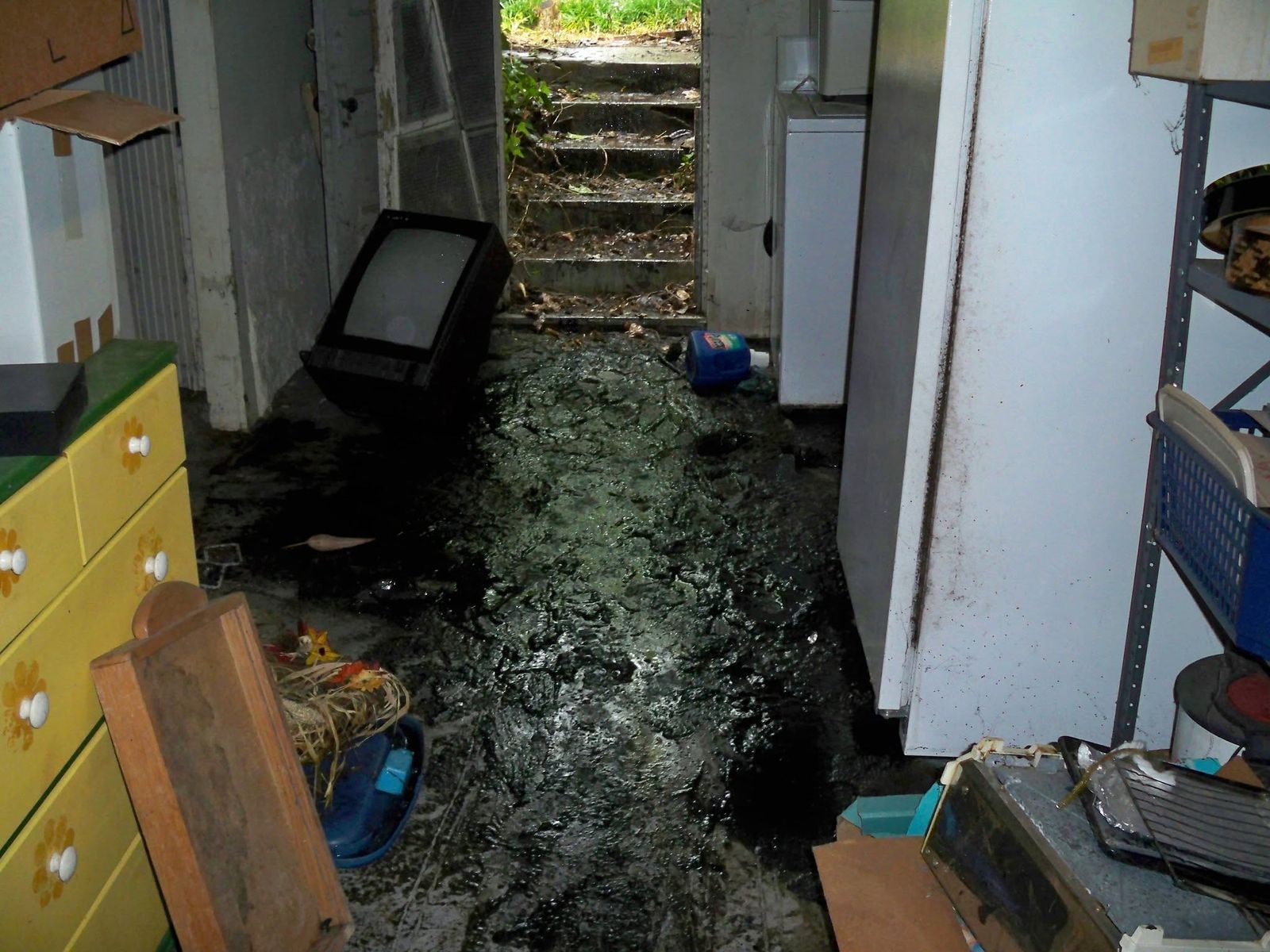 A wider view of the flooded hallway, with furniture and debris