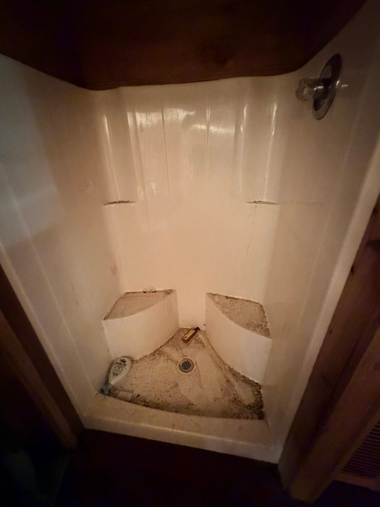 A grimy fiberglass shower stall before cleaning