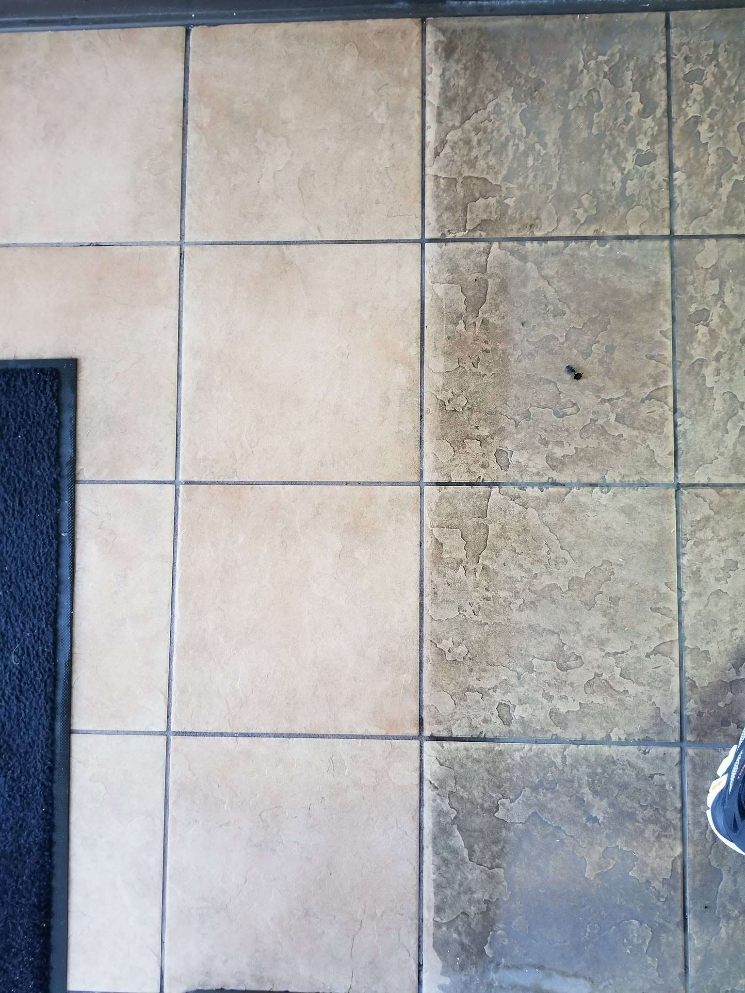 Floor tile and grout, one side noticeably darker than the other